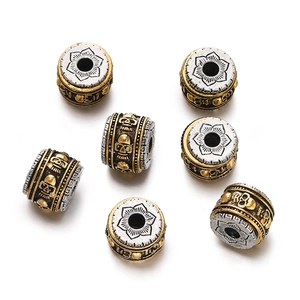 Macro view of vintage tibetan silver beads with gold plating and skull pattern relief