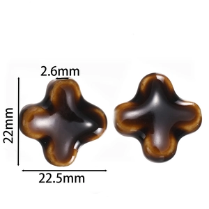 Macro detail of cross-shaped ceramic beads with dimensions of 22mm x 22.5mm and 2.6mm hole