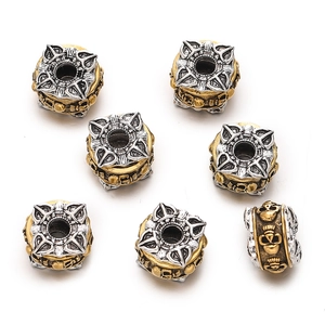 Macro view of seven retro gothic style beads with gold skull and silver flower patterns