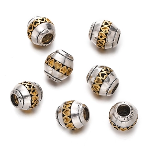 Macro detail of silver and gold barrel beads with heart patterns and Love engraving