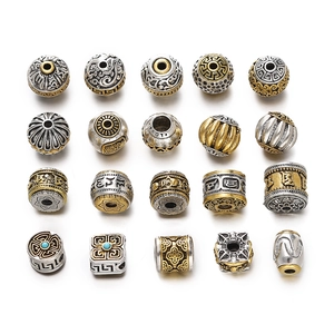 Detailed view of 20 vintage Tibetan style alloy beads with relief cloud and fret patterns