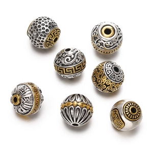 Macro detail of seven antique silver and gold plated beads with meander relief patterns