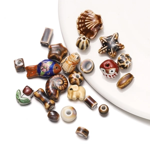 Assorted ceramic beads featuring owl, elephant, and starfish shapes on a white plate