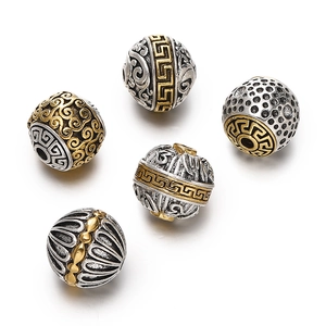 Macro view of five antique silver and gold plated Tibetan style alloy spacer beads