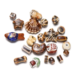 Macro shot of assorted ceramic beads including starfish and elephant shapes with kiln glaze