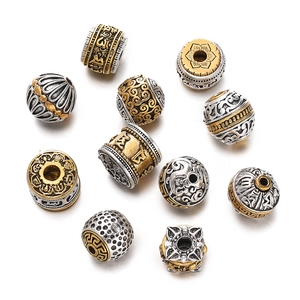Macro detail of silver and gold plated metal beads with traditional lotus engravings