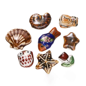 Macro detail of hand-painted ceramic charms including owl, shell, and elephant shapes