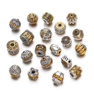Macro detail of mixed gold and silver Tibetan style alloy beads with intricate ethnic patterns