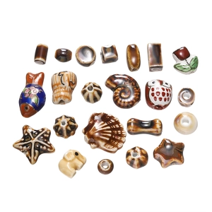 Detailed macro shot of assorted ceramic beads including starfish, owls and elephant shapes