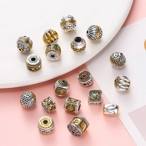 Detailed view of Tibetan-style antique gold and silver alloy beads with auspicious patterns