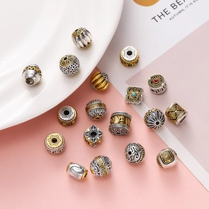 Detailed view of vintage silver and gold ethnic beads with lotus and cloud patterns