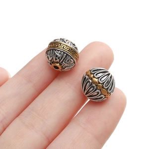 Macro view of two-tone vintage alloy beads featuring ethnic cloud patterns for jewelry DIY