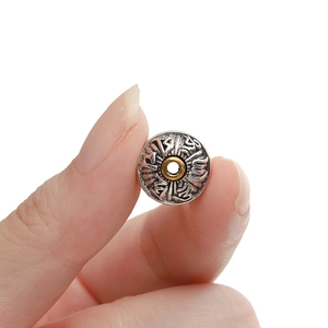 Close-up of Tibetan style silver bead with gold center and Sanskrit mantra carvings