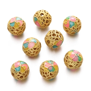 Macro view of hollow golden enamel round beads with colorful floral motifs for DIY jewelry