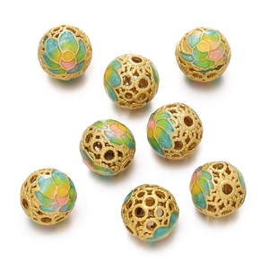 Macro shot of gold hollow enamel beads with floral patterns for jewelry making