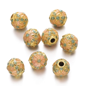 Close-up of golden hollow cloisonne enamel beads with pink and green floral textures