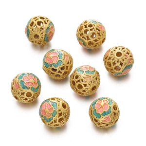 Detailed view of hollow gold filigree enamel beads with pink and green floral patterns