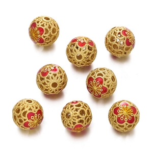 Macro detail of golden hollow cloisonne beads with red and yellow enamel plum blossoms