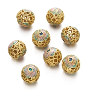 Macro shot of seven gold cloisonne hollow beads with colorful enamel floral patterns