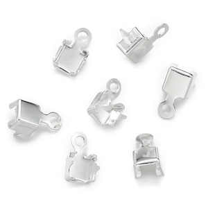 Close-up of silver metal fold-over crimp ends and clasp connectors for DIY jewelry making