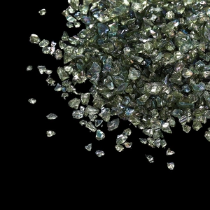 Gros plan d'éclats de verre vert clair irisé pour nail art DIY sur fond noir