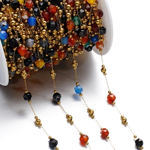 Detail of colorful faceted stone beads and gold metal spacers on a DIY jewelry chain roll