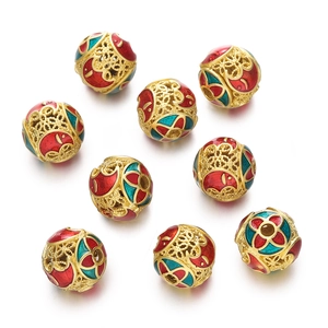 Macro shot of gold hollow filigree cloisonné beads with red and blue enamel patterns