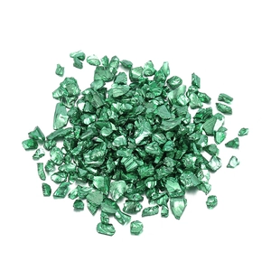 Gros plan de 450g de pierres en verre vert émeraude irrégulières avec finition métallique