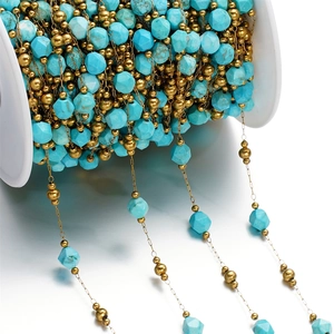 Detailed macro view of turquoise stone beads and gold beads on a white plastic spool
