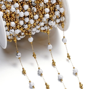 Macro detail of white marble faceted beads with gold spacers on DIY jewelry chain