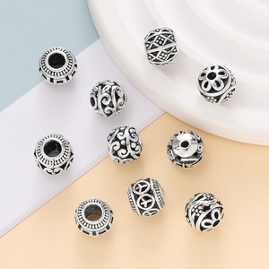 Macro detail of retro silver cloisonne beads with floral and geometric hollow patterns