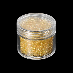 Macro view of iridescent champagne glass beads in a clear jar for DIY resin art and nail decoration