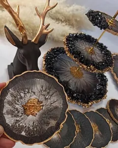 Dettaglio macro del sottobicchiere in resina con pietre nere e finiture in foglia oro