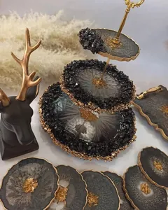 Macro detail of luxury three-tier resin dessert stand with gold foil and black crushed crystals