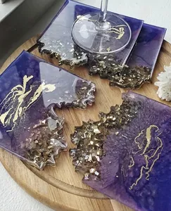 Close-up of handmade purple geode resin coasters with gold foil and jagged edges