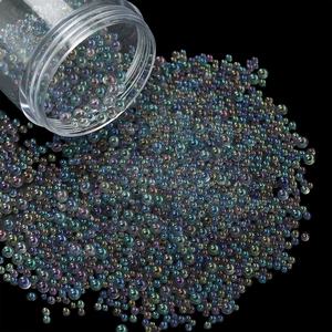 Macro detail of mixed size iridescent glass bubble beads pouring for DIY nail art