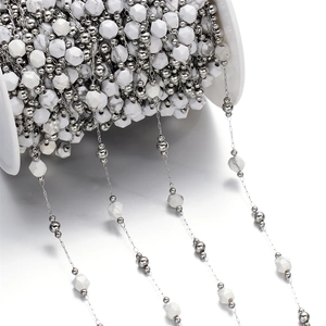 Detailed macro of white marbled stone beads on silver chain for jewelry making