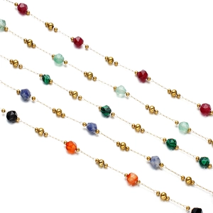 Macro view of gold stainless steel faceted colorful natural stone chain links