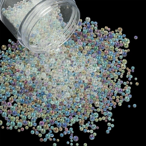 Macro shot of iridescent AB glass bubble beads pouring from a clear bottle for nail art DIY
