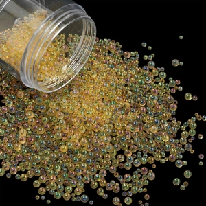 Macro shot of iridescent champagne glass beads pouring from a bottle on black background