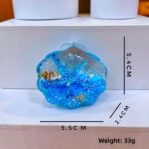 Detail view of shell liquid keychain with blue glitter and 5.4x5.5cm size markings