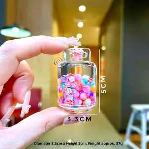 Gros plan détaillé d'un mini bocal en acrylique avec perles colorées et breloques fleurs