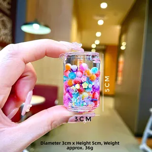 Détail d'un porte-clés mini bouteille avec perles colorées et paillettes liquides