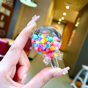 Vue détaillée du porte-clés bouteille de bonbons cœur avec perles colorées et nœud papillon