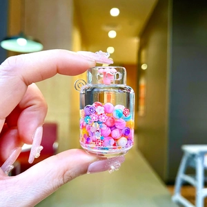 Gros plan d'un porte-clés bouteille de bonbons avec perles colorées et sable mouvant