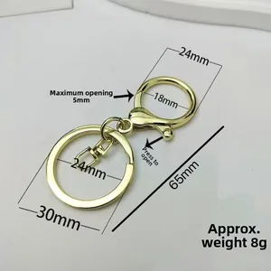 Detailed view of golden apple keychain with precise dimensions and spring lobster clasp