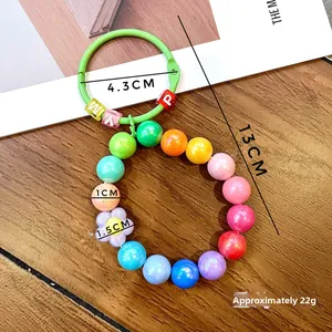 Detail of colorful beaded keychain with pastel beads and a green plastic ring