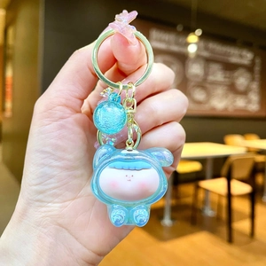 Detail of light blue acrylic keychain featuring glittery character and golden clasp