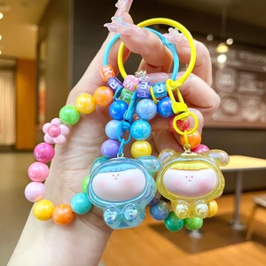 Colorful DIY beaded keychain with hooded dolls and alphabet cubes in hand display
