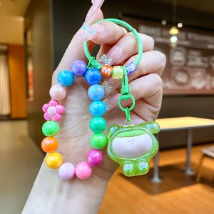 Detail of colorful resin bead keychain with translucent cartoon figurine and spring clasp